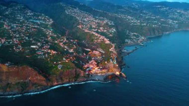Dağın yamacındaki yüksek nüfuslu bölge Atlantik Okyanusu 'nun sularına iniyor. Portekiz 'in Madeira Adaları kıyılarında hava perspektifi.