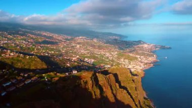 Portekiz 'in Madeira Adaları' nın pitoresk sahili üzerinde. Atlantik Okyanusu 'nun kayalık bir kıyısındaki yerleşim bölgesinde. Arkaplanı kaplayan dramatik bulutlu manzara.