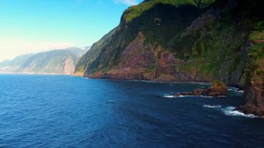 Portekiz 'in Madeira Adaları' nın sahil şeridinde yeşil yosunlarla kaplı dev dağlar. Atlantik Okyanusu 'nun su üzerinde alçak açılı kayalıklarla uçmak.