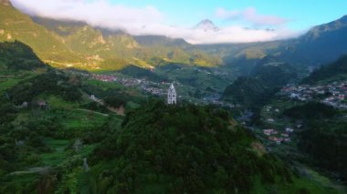 Portekiz 'in Madeira Adaları' ndaki Fatima Sao Vicente Kilisesi 'ne bakın. Resimli dağlarda bulunan nefes kesici yaşam alanı üzerine hava perspektifi. Kayaların tepelerini beyaz bulutlar kaplıyor..