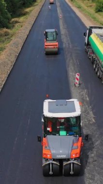 Titreşim silindiriyle tamir ediliyor. Yeni asfalt yolun dikey görüntü altında havadan görüntüsü