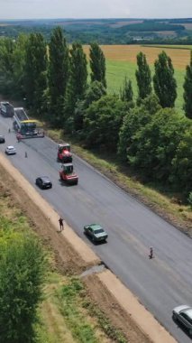 Yol yapım ekipmanları. Dikey video asfalt kaldırma sırasında yol onarım alanında asfalt kaldırıcı, silindir ve kamyon