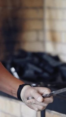 Şef barbekü hazırlıyor. Aşçı, şiş şişlerden kavrulmuş sulu eti alır ve bir tabak koyar. Lezzetli shashlik restoranda yemeğe hazır. Dikey video