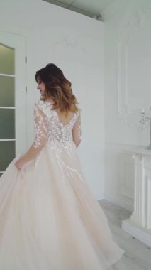 Profesyonel makyajlı bir kadın portresi. Gelinlikli modelin stüdyo içi görüntüsü Dikey video