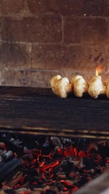 Izgarada mantar pişirmek. Aşçı kömürün üzerine tavuk eti koyuyor. Restoranın mutfağındaki barbeküyü hazırlıyorum. Dikey video