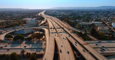 Modern metropolün birden fazla güneşli otoyolu tarafından işletilen arabalar. Los Angeles, California, ABD 'nin hava perspektifi. Arka planda metropolü kaplayan sis.
