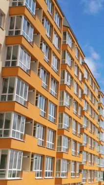 Modern apartman binalarının dış görünüşü. Çağdaş turuncu ve beyaz binalar. Açık hava tesisleri, dikey video.