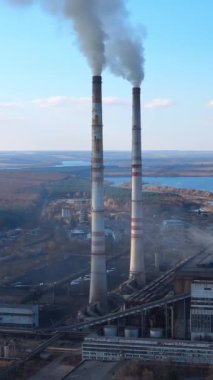 Endüstriyel dumandan kaynaklanan atmosfer kirliliği. Endüstriyel fabrikadan çıkan kimyasal dumanlı borular. Kalın duman ve buhar çevreyi kirletir. İklim değişikliği ve küresel ısınma Dikey video