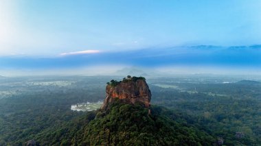 Sri Lanka dağları üzerinde çarpıcı bir şafak. Sri Lanka 'da yemyeşil yemyeşil bir dağ yükseliyor. Şafağın dingin güzelliğini yakalıyor ve manzarayı sisle kaplıyor..