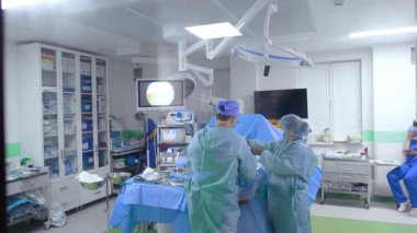 Erkek doktor ve kadın ameliyat hemşiresi ameliyat masasında. Kapıdaki pencereden ameliyathaneye bir göz at..