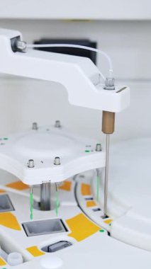 Modern bilim laboratuarında çalışan ekipmanlar. Kapatın. Hastanedeki kan testleri için gelişmiş bir cihaz. Dikey video
