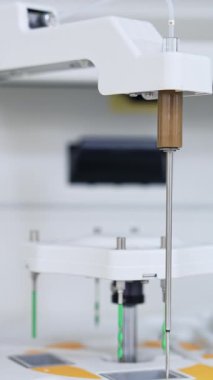 Makine müfrezesi aşağı inip yukarı hareket ediyor. Gelişmiş ekipmanlar bilimsel tıbbi analiz ve testler yapıyor. Kapatın. Arkaplan bulanık. Dikey video