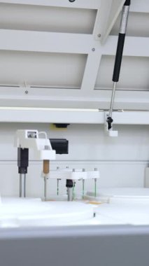 Büyük bir laboratuvar makinesi çalışıyor ve kan biyomedikal testleri yapıyor. Fen laboratuarında gelişmiş yenilikçi ekipmanlar. Dikey video