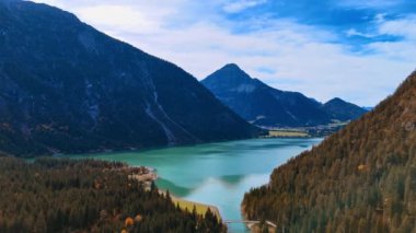 Dağlar arasında çam ağaçlarıyla kaplı güzel bir göl manzarası. Tyrol 'daki Plansee Gölü' nün havadan görünüşü, Alpler 'deki Avusturya.