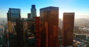 Los Angeles, Kaliforniya 'nın merkezindeki gökdelenlerin etrafında uçuyor. Şehir arka planda sisle kaplıdır..