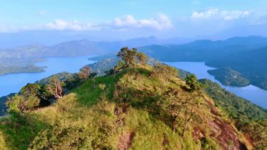 Yeşil çimlerle kaplı güzel dağın tepesindeki görüntüler. Sisli zeminde ayaklarının dibinde sersemletici kayalar var. Üst görünüm.