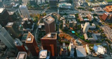 Güzel gökdelenlerin tepesinde helikopter platformları var. Şehir merkezindeki Los Angeles otoyollarında çoklu taşıma akışı. Üst görünüm.