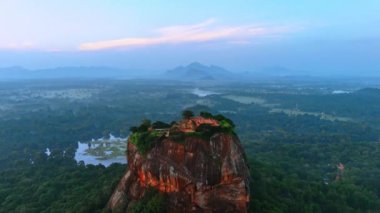 Sri Lanka 'daki Sigirya kalesinin harabelerinden çok sayıda turist geçiyor. Arkaplanda puslu manzaralı Aslan Kayası.