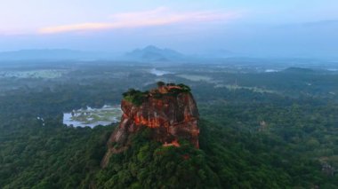 Kahverengi dağın etrafındaki yemyeşil alanda görüntüler. Sri Lanka 'daki Sigirya kaya kalesine hava perspektifi.