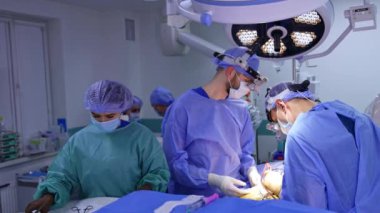 Cerrahi loplarda çalışan iki cerrah ameliyat yapıyor. Kadın hemşire modern beyin cerrahisinde doktorlara yardımcı oluyor..