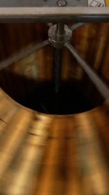 Elektrikli santrifüj cihazının yardımıyla bal çıkarma. Baldan kurtulmak için bal petekli ahşap çerçeveler dönüyor. Üst Manzara. Dikey video