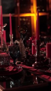 Noel yemeği için yemek masası hazır. Noel ağacı arka planında mumlarla süslenmiş bir şenlik masası. Kutlama servisi. Dikey video