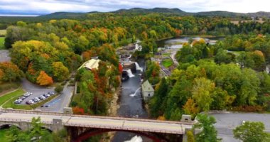 Adirondacks 'taki Ausable Chasm' daki şelaleye yaklaşan kemer köprüsünün üzerindeki uçuş. Güzel orman sonbaharda renk değiştiriyor..