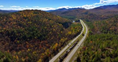 Taşıma araçları ABD 'nin Kuzey New York Eyaleti' nin dağlık kesimindeki otobanlardan geçiyor. Şehirlerden uzakta, doğada güneşli bir sonbahar günü. Üst görünüm.