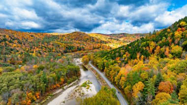ABD 'nin sakin ve nehir manzaralı sonbahar renkleri. ABD 'de huzurlu bir sonbahar gününde, canlı sonbahar yaprakları tepeleri ve kıvrımlı bir nehir, doğanın güzelliğini gözler önüne seriyor..