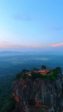 Gün batımında Sri Lanka 'daki Sigiriya Kalesi' nin manzarası. Arkaplanda yeşil manzaraların puslu manzarası. Dikey video.