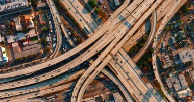 Gün batımında kavşakta otobanlardan ve otobanlardan geçen bir araç. Los Angeles 'taki trafiğin en üst görüntüsü.