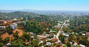 Hollywood tepelerine çeşitli kulübelerle yaklaşıyorlar. Los Angeles 'taki hava perspektifi arka planda sis ile kaplıydı.