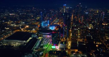 Geceleri hareketli, uykusuz bir şehir. İHA görüntüleri Los Angeles, California, ABD şehir merkezine yaklaşıyor. Metropolis 'in binalarında neon ışıkları yanıp sönüyor..