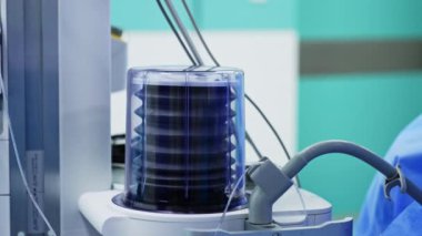 Akciğer solunum pompası yukarı ve aşağı gidiyor. Modern tıbbi ekipmanlar ameliyathanede çalışıyor. Kapatın. Sıhhiye arka planda bulanık yürüyor.