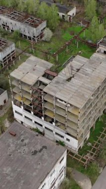 Yıkılmış fabrika binaları. Fabrika bölgesinde terk edilmiş depolar ya da üretim departmanı. Yıkım için eski endüstriyel yapılar. Hava görüntüsü. Dikey video