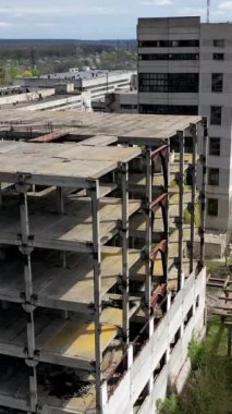 Yıkılmış binalar. Eski bir sanayi fabrikasının terk edilmiş toprakları. Yıkılmış binaları olan eski bir fabrika. Hava uçuşu. Dikey video