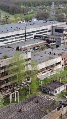 Eski bir fabrikanın panoramik manzarası. Büyük tuğla boruları olan terk edilmiş sanayi bölgesi. İlkbaharda üretimi mahvoldu. Hava görüntüsü. Dikey video