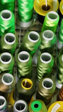 Renkli iplik koleksiyonu. İpliklerin farklı renklerde makaraları. Dikiş ipliklerinin arka planı. El işi konsepti. Dikey video