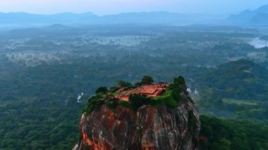 Sigirya kalesi çok sayıda turistin geçtiği bir harabe. Sri Lanka 'nın puslu manzarasından yükselen resim gibi bir dağ. Hava görünümü.