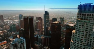 Metropolis şehir merkezindeki en yüksek gökdelenlerin tepesindeki görüntüler. Arka plandaki şehir manzarası sisli. Los Angeles, Kaliforniya, ABD.