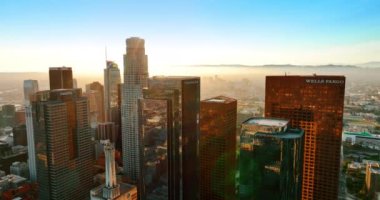 Los Angeles, California, ABD şehir merkezindeki çarpıcı gökdelenler. İnsansız hava aracı yoğun sisle kaplı güneşli şehir arazisinde yükseliyor..