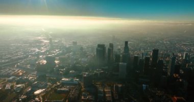 Kaliforniya, Los Angeles 'ın muazzam puslu manzarası güneş ışığıyla parlıyordu. Şehir merkezinin üstündeki metropol üzerine hava perspektifi.