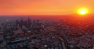 Çarpıcı Los Angeles, California, ABD manzarasında turuncu ve kırmızı ışık. Gün batımında şehir merkezinde ve şehrin yukarısında hava perspektifi.