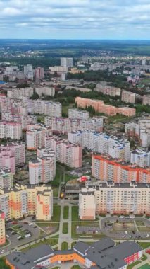 Modern şehir manzarası. Yeni bir bölgedeki renkli şehir binaları. Vatandaşlar için çok katlı daireler. Hava görüntüsü. Dikey video