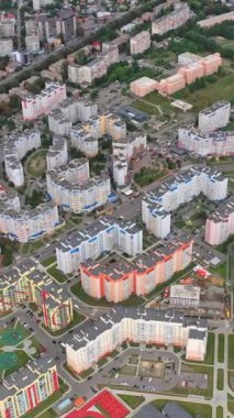 Kentsel arka planda çağdaş yüksek binalar. Modern bölgedeki vatandaşlar için konutlar. Hava görüntüsü. Dikey video