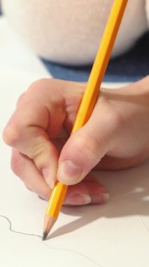 Grafit kalemli kadın elleri. Genç bir kadın resim yapmayı öğreniyor. Dikey video