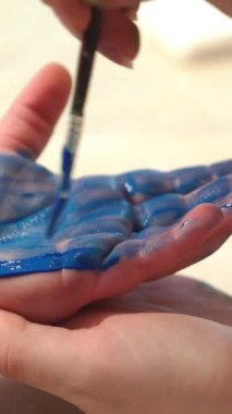 Renkli boyayla boyanmış çocuk eli. Erken çocukluk eğitimi. Küçük ressam. Dikey video