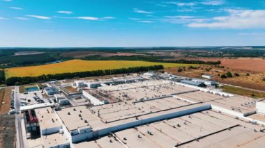 Modern endüstriyel fabrikanın sayısız tesisi. Kırsal alan, tarımsal tarlalar ve arka plandaki ormanlar. Hava görünümü.