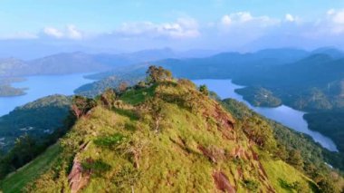 Çimlerle ve ağaçlarla kaplı yüksek kayaların tepesinde. Havadan bakıldığında Sri Lanka 'nın resimli dağları ve gölleri.