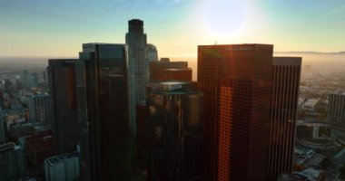 Los Angeles, California, ABD şehir merkezindeki cam gökdelenler. İnsansız hava aracı gün batımında şehir merkezindeki yüksek binalara iniyor..